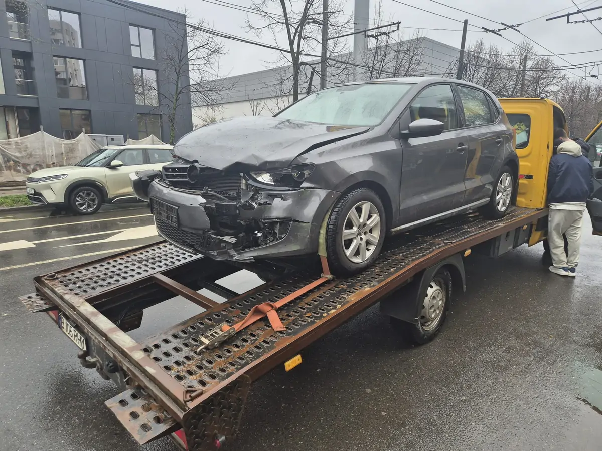 Volkswagen avariat tractat pe platformă în București