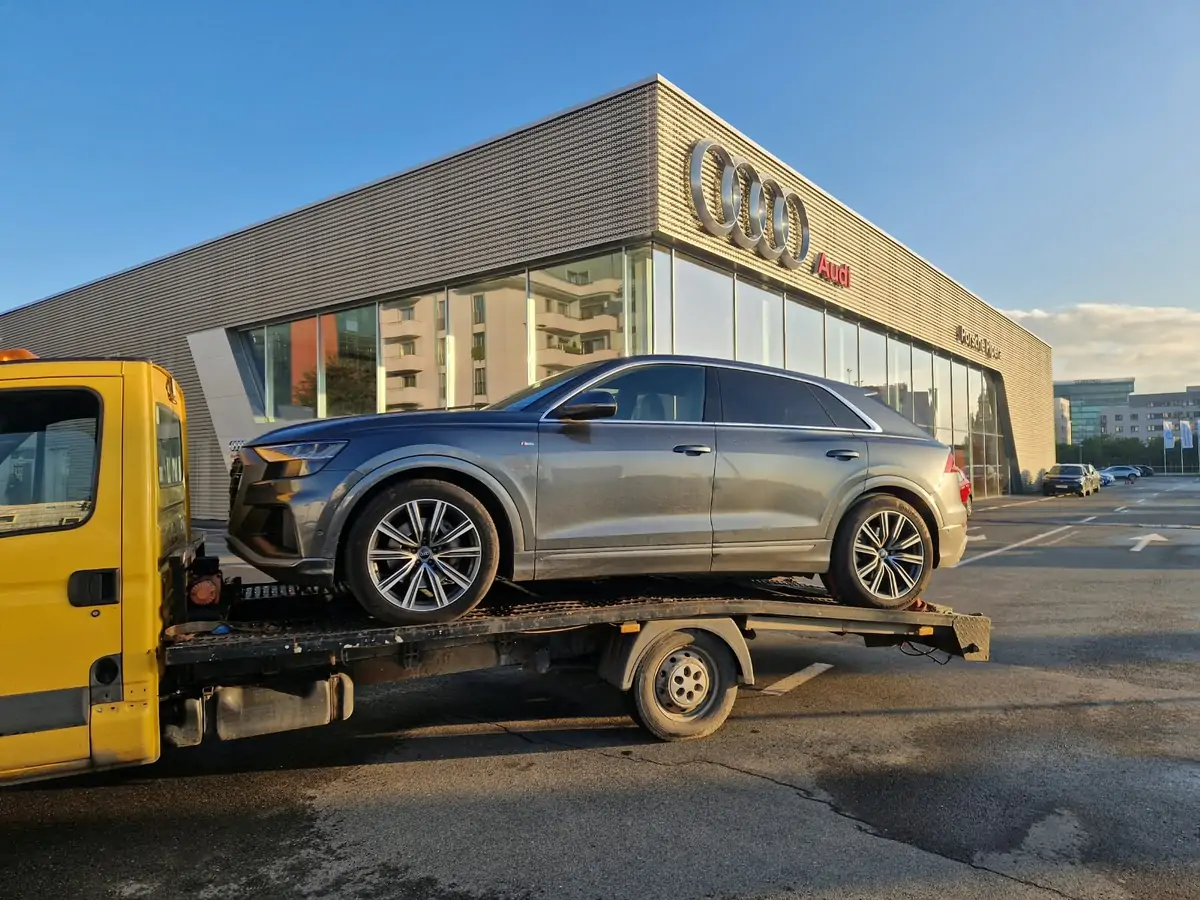 Audi transportat pe platformă la o reprezentanță auto