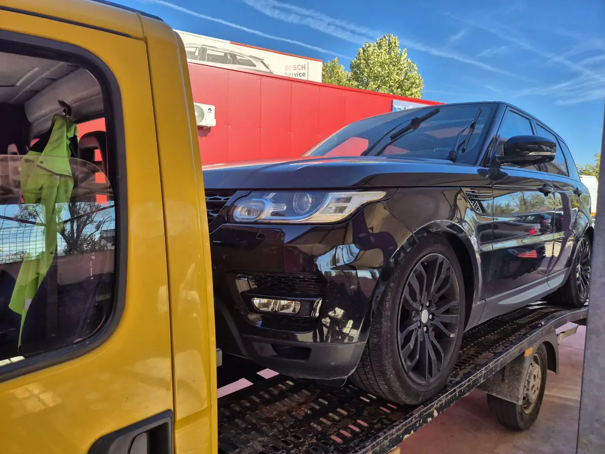 Range Rover negru pe platformă auto în București