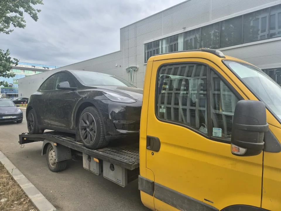 SUV negru transportat pe platforma auto galbenă